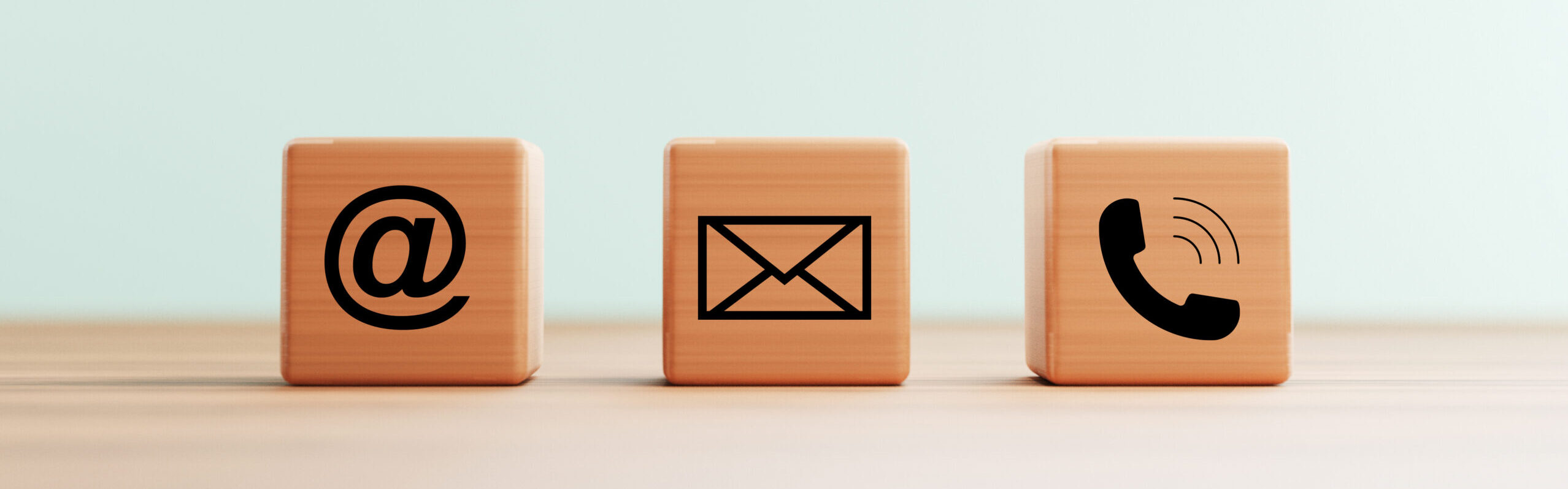 Holzwürfel auf einem Tisch mit E-Mail-Adresse, Telefonnummer und Buchstabensymbolen